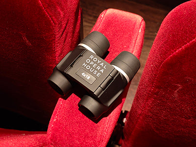 Royal Opera House Opera Glasses on a red velvet seat in the auditorium